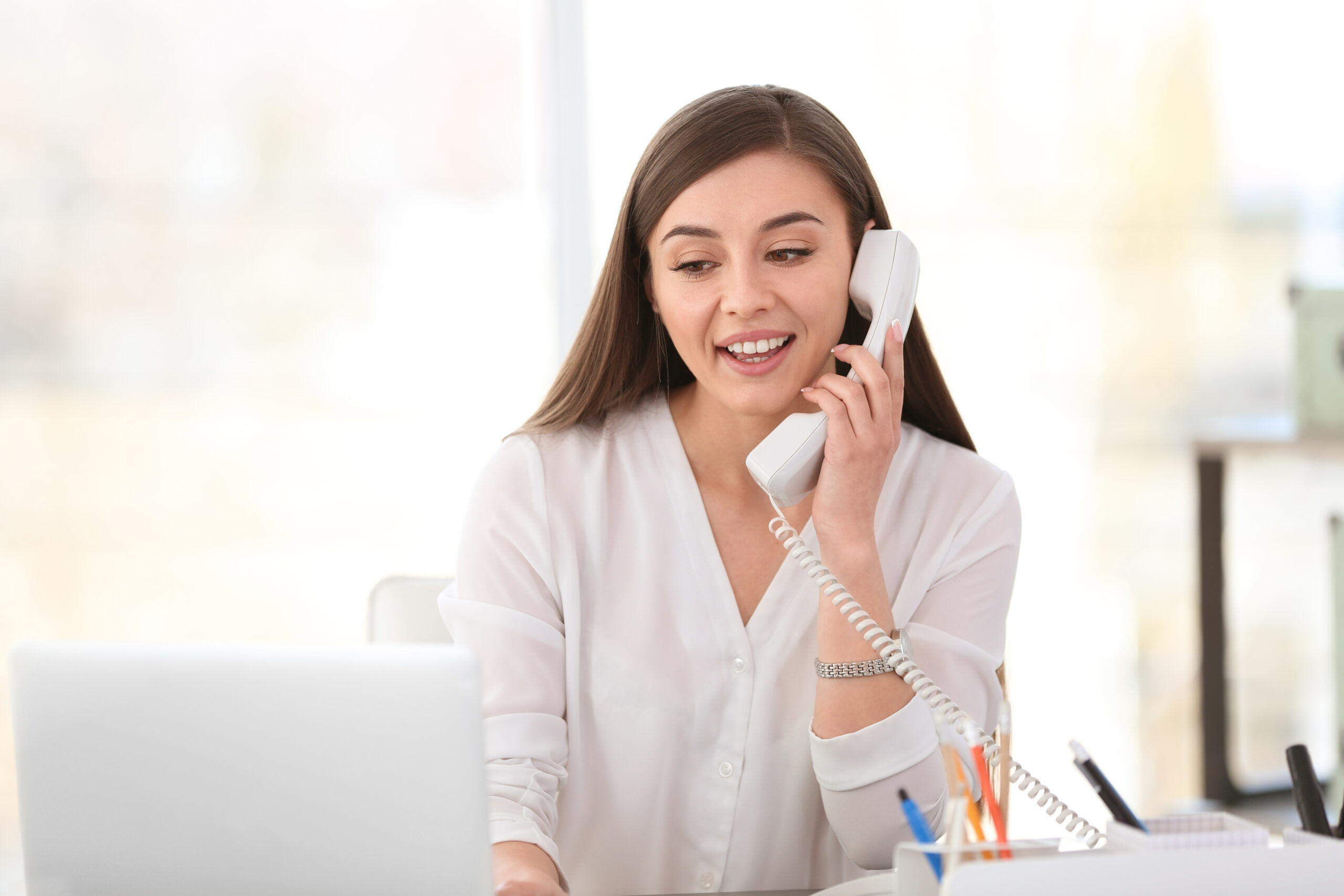 Young woman talking on phone at workplace